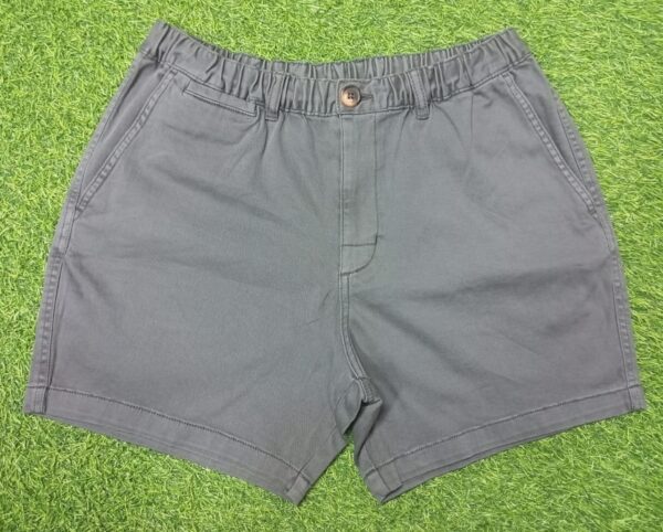 Man wearing charcoal grey casual men's shorts with front pockets and a black t-shirt, standing against a white background.