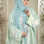 Woman wearing a mint green Dubai Imported Original Farasha Abaya with silver detailing and a matching hijab.