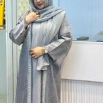 Woman wearing a Nida Boutiques Original Borka in grey with silver embroidered detailing, styled with a matching hijab at Hayah by Robe.