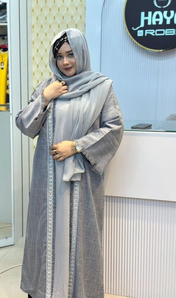 Woman wearing a Nida Boutiques Original Borka in grey with silver embroidered detailing, styled with a matching hijab at Hayah by Robe.