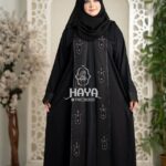 Woman in a black premium 2-part koti borka featuring intricate embroidered patterns and matching hijab.