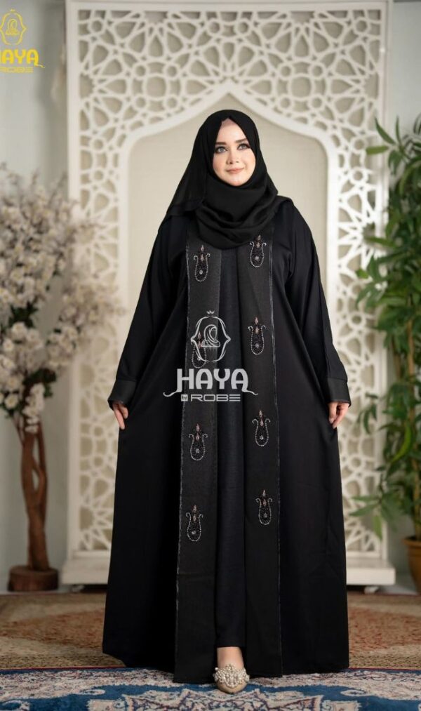 Woman in a black premium 2-part koti borka featuring intricate embroidered patterns and matching hijab.